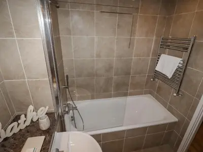 a bathroom with a shower with a tub and a toilet at Sky in St Ives