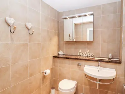 a bathroom with a toilet and a sink and a mirror at Sky in St Ives