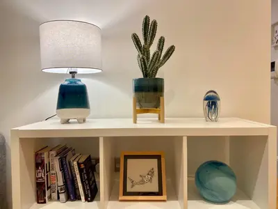 a white shelf with a lamp and a plant on it at Amazing 2-bedroom apartment with lovely sea views in Newquay