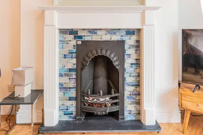 a brick fireplace with a white and blue at The Slipway Fowey Harbour Parking 1 Min & Garden in Fowey
