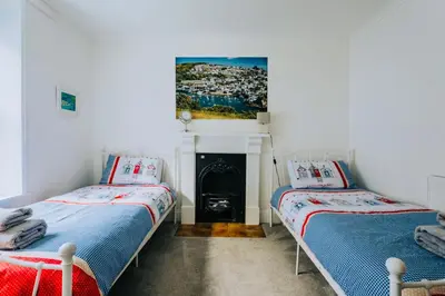 two beds in a room with a fireplace at The Slipway Fowey Harbour Parking 1 Min & Garden in Fowey