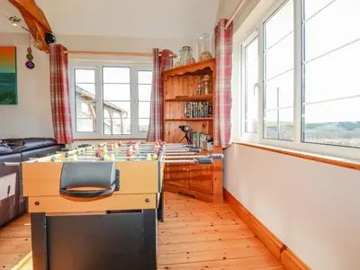 a room with a desk with a chair and windows at Penlaurel in Bude
