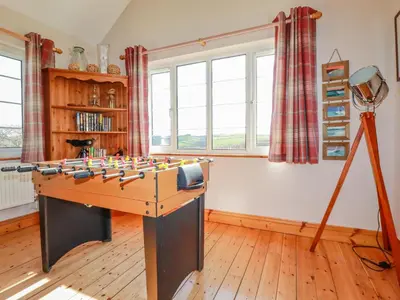 a room with a foosball table and a tripod at Penlaurel in Bude