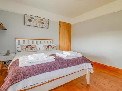 a bedroom with a bed with two towels on it at Penlaurel in Bude