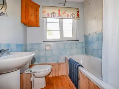 a bathroom with a toilet and a sink and a tub at Penlaurel in Bude