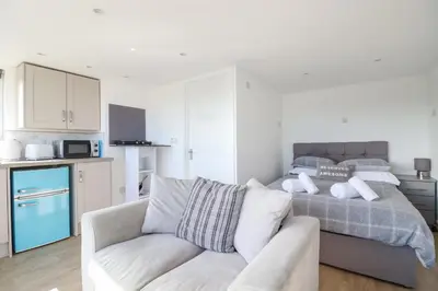 a living room with a bed and a couch at Gannel Hideaway in Newquay