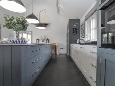 a kitchen with white cabinets and a black refrigerator at Wood Meadow in Helston