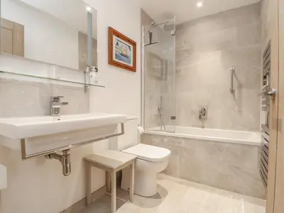 a bathroom with a sink and a toilet and a shower at Wood Meadow in Helston