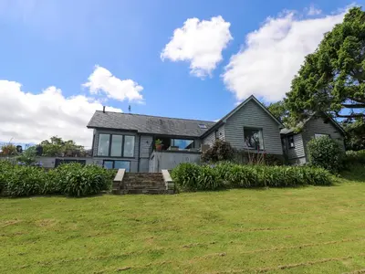 a house with a grass yard in front of it at Wood Meadow in Helston