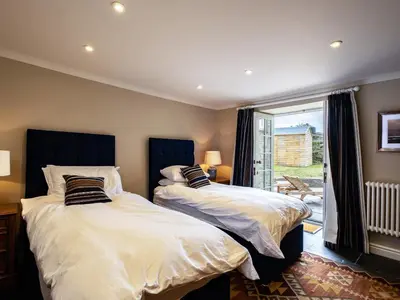two beds in a room with a window at Porthilly Greys in Padstow