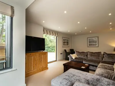 a living room with a couch and a flat screen tv at Porthilly Greys in Padstow