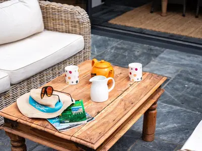 a coffee table with a hat and cups on it at Porthilly Greys in Padstow
