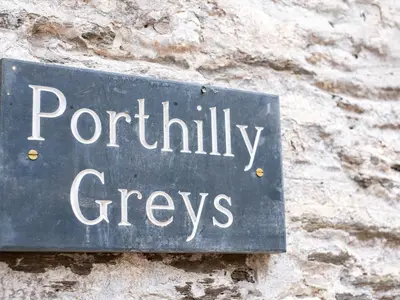a sign on the side of a stone wall at Porthilly Greys in Padstow
