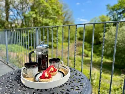 a table with a plate with two cakes and two cups at Trewethen Cottage Barn 2 near Port Isaac in Port Isaac