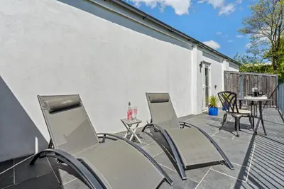 a patio with chairs and a table and a table at Trewethen Cottage Barn 2 near Port Isaac in Port Isaac