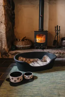 a fireplace with two bowls and a pan in front of it at Kitts Cottage, Redruth, Cosy Cornish Retreat in Redruth