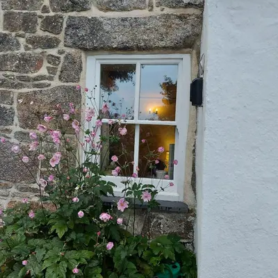 a window of a building with pink flowers at Kitts Cottage, Redruth, Cosy Cornish Retreat in Redruth