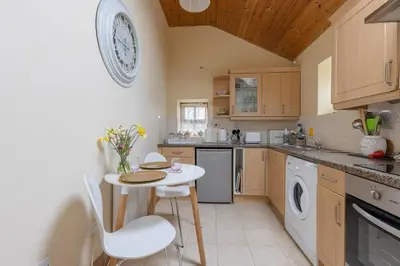 a kitchen with a small table and chairs in it at Kitts Cottage, Redruth, Cosy Cornish Retreat in Redruth