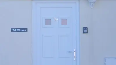 a white door with a sign that reads ways at Waves in Saint Columb Major