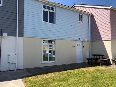 a building with a picnic table in front of it at Waves in Saint Columb Major