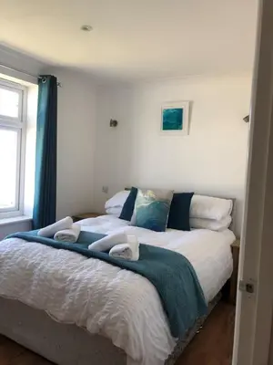 a bedroom with a bed with two towels on it at Waves in Saint Columb Major