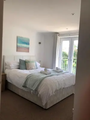 a bedroom with a large bed with a window at Waves in Saint Columb Major