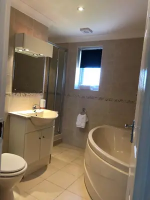 a bathroom with a toilet and a sink and a tub at Waves in Saint Columb Major