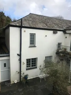 a white house with two chairs in front of it at Spring Garden Cottage in Wadebridge