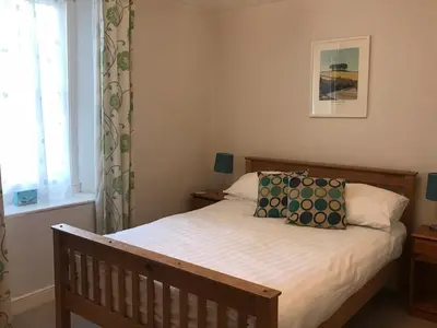 a bedroom with a bed with two pillows on it at Spring Garden Cottage in Wadebridge