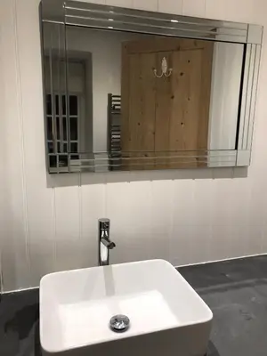 a bathroom sink with a large mirror above it at Spring Garden Cottage in Wadebridge
