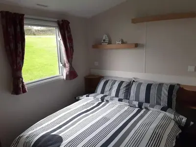 a bedroom with a bed and a window at 58 Newquay View, Newquay Bay Resort in Porth