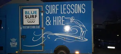 a blue truck with white writing on the side of it at 58 Newquay View, Newquay Bay Resort in Porth