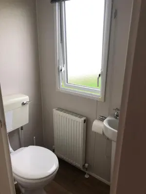 a bathroom with a toilet and a sink and a window at 58 Newquay View, Newquay Bay Resort in Porth