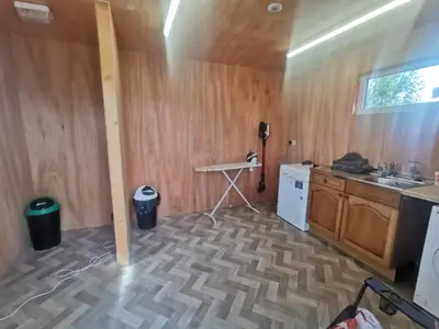 a kitchen with a counter and a table in a room at Glamping Pods Nr Port Isaac in Port Isaac