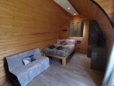 a room with a bed and a couch in a room at Glamping Pods Nr Port Isaac in Port Isaac