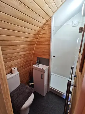 a small bathroom with a toilet and a shower at Glamping Pods Nr Port Isaac in Port Isaac