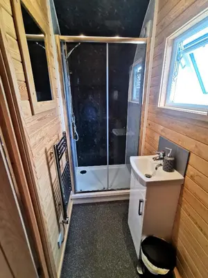 a bathroom with a sink and a shower at Glamping Pods Nr Port Isaac in Port Isaac