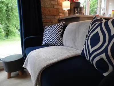 a couch with pillows on it next to a window at Seaside Escape in St Ives
