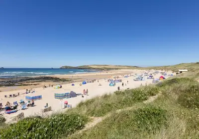 a group of people on a beach near the ocean at Wendy Lodge- Chalet Cottage, Sleeps 6 Adults in Padstow