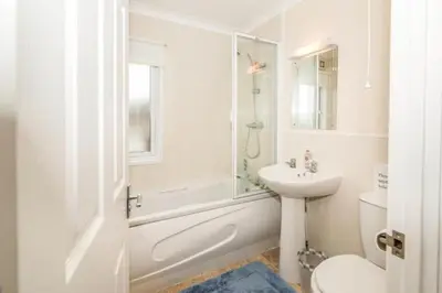 a bathroom with a sink and a toilet and a shower at Wendy Lodge- Chalet Cottage, Sleeps 6 Adults in Padstow