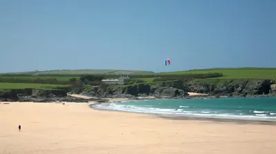 a person on a beach with a kite in the sky at Wendy Lodge- Chalet Cottage, Sleeps 6 Adults in Padstow