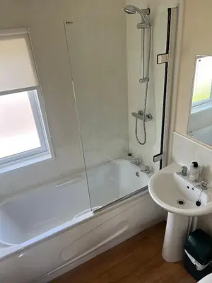 a bathroom with a shower and a tub and a sink at Wendy Lodge- Chalet Cottage, Sleeps 6 Adults in Padstow