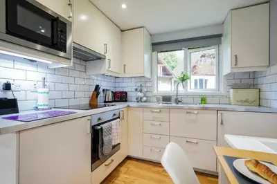 a white kitchen with white cabinets and a sink at Cornish Holiday - 91 Hengar Manor in Saint Tudy