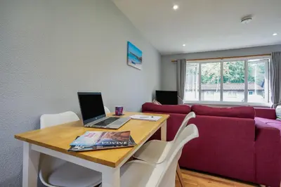 a living room with a couch and a table with a laptop at Cornish Holiday - 91 Hengar Manor in Saint Tudy