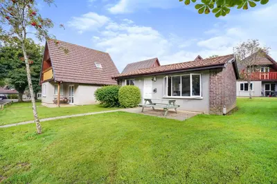 a house with a picnic table in a yard at Cornish Holiday - 91 Hengar Manor in Saint Tudy