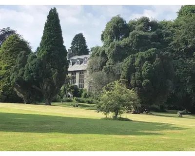 a large house in the middle of a green field at Cornish Holiday - 91 Hengar Manor in Saint Tudy