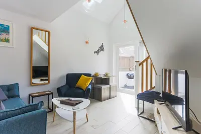 a living room with two blue chairs and a table at Little Cedars House in Truro