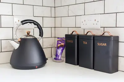 a tea kettle and two books on a kitchen counter at Little Cedars House in Truro
