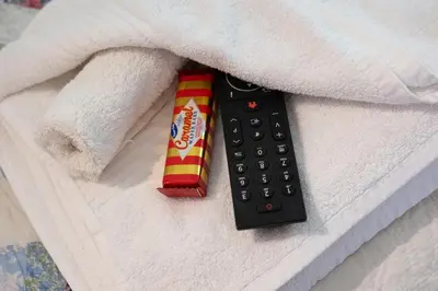 a remote control and a candy bar on a bed at Charming Guest House in Cornish Countryside in Bodmin