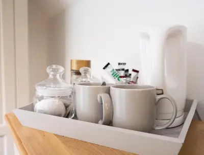 a shelf with cups and a glass jar on it at Charming Guest House in Cornish Countryside in Bodmin